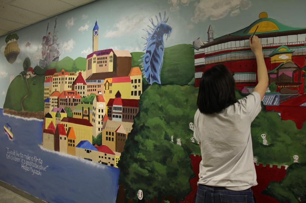 Serafina Urrutia | Hawkeye
Senior Kyra Dahlman works on a mural that adorns the walls of the art hallway. 
