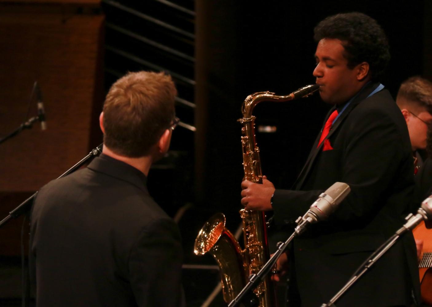 Senior Dylon Rajah solos on Such Sweet Thunder while director Darin Faul watches from the front of the stage. Today Rajah was making his dream come true, as hes been working for this moment since he began jazz.