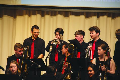 The MTHS Jazz 1 brass section looks on as senior Solomon Plourd plays a thick, blues-laden solo during the final concert of the University of Oregon Jazz Festival. 