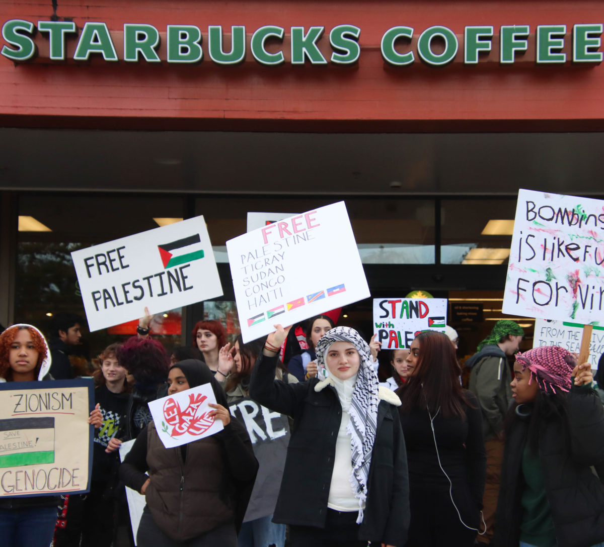 Terrace senior Sarah Al-Maiahi holds up a sign, which states “Free Palestine, Tigray, Sudan, Congo, and Haiti” while she and the rest of the student protesters stand outside the front of Starbucks in Cedar Plaza.