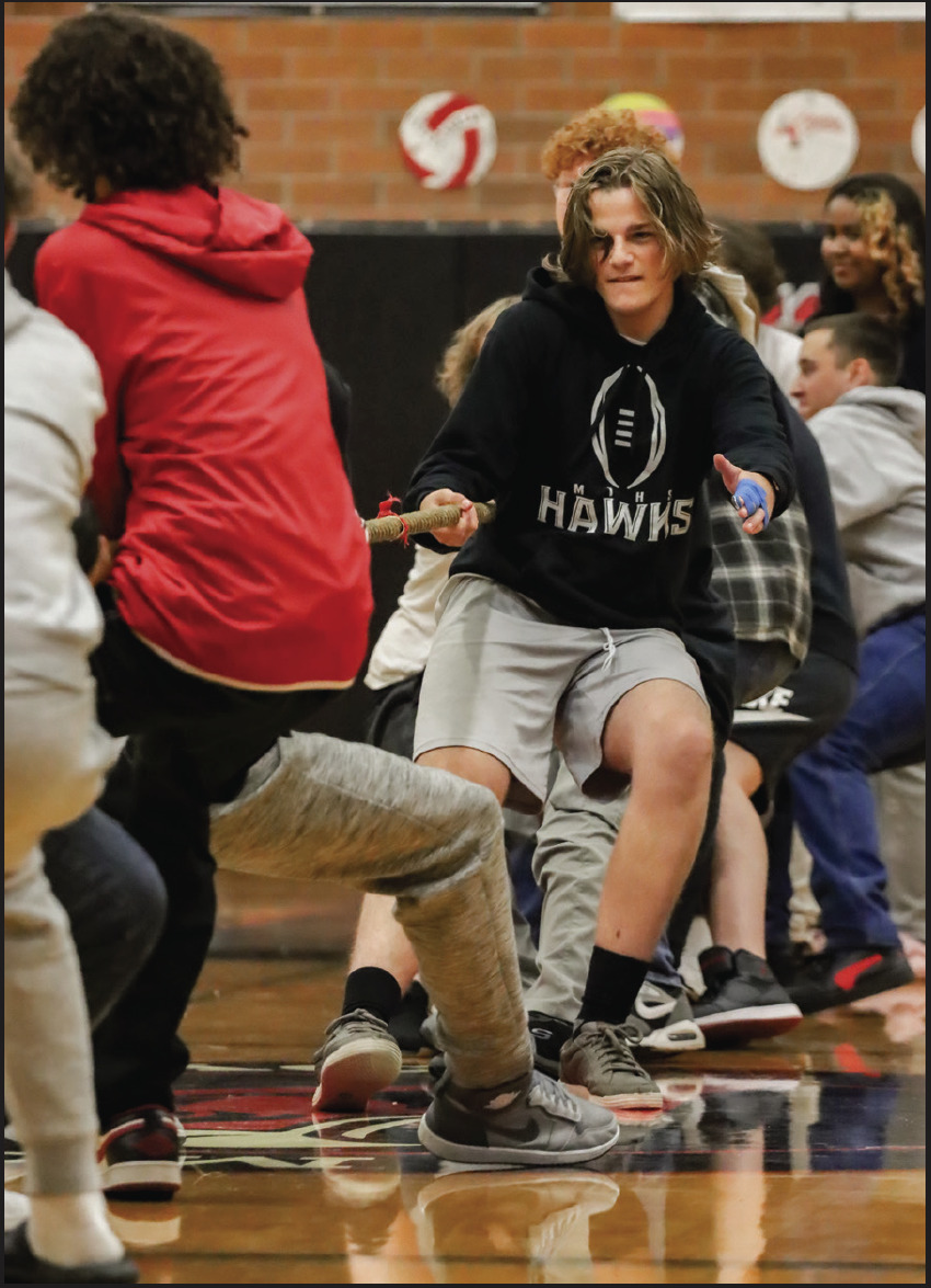 Junior Bryce Pawling pulling at the rope with all his might during the “Tug of War” game in the homecoming assembly.