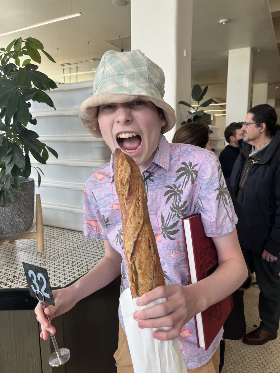 Evan Kerani posing with his outfit from Arizon Trading Co. and a baguette during the journalism national convention in Kansas City, Missouri in April 2024.