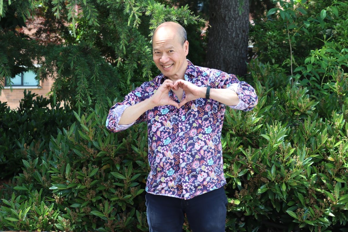 Science teacher Jonathon Tong strikes a heart hand pose as a final farewell to the students and faculty he has worked beside for the past 23 years.