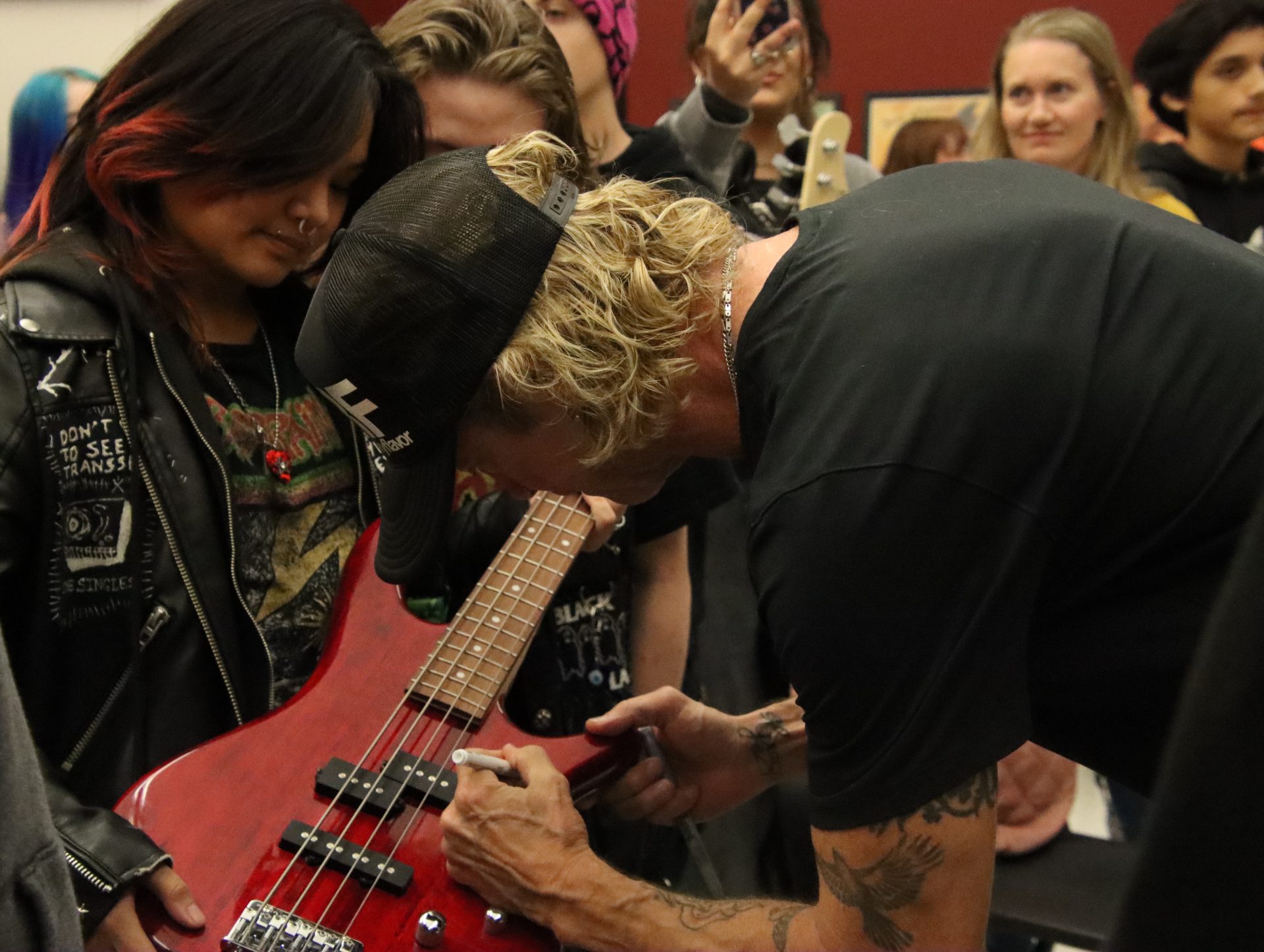 Guns and Roses bassist, Duff McKagan signs a student's bass.