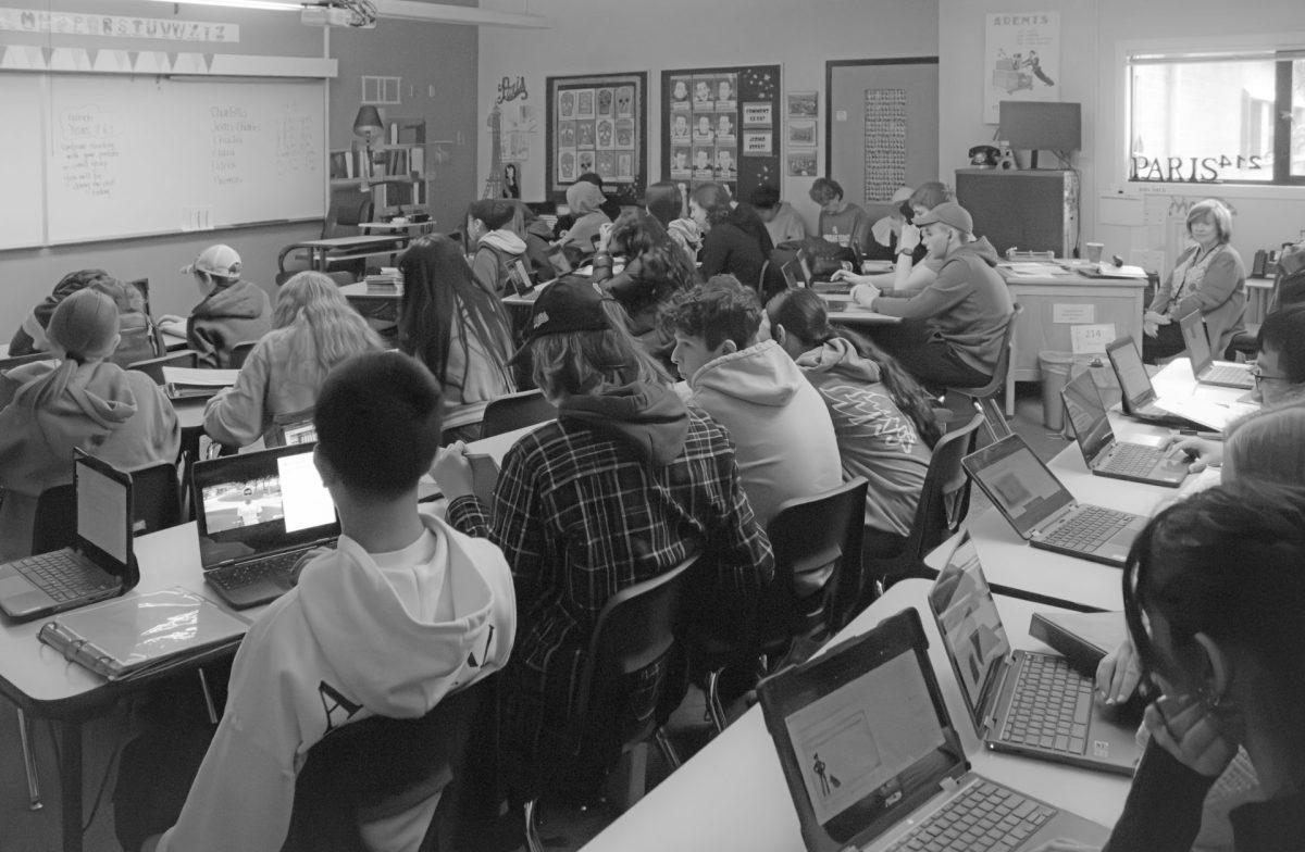 Language teacher Heidi Monrad’s class works elbow to elbow on an assignment while a substitute looks on. Some students sit on the very end of tables, with others backed up against the wall in a class with well over 30 enrolled.