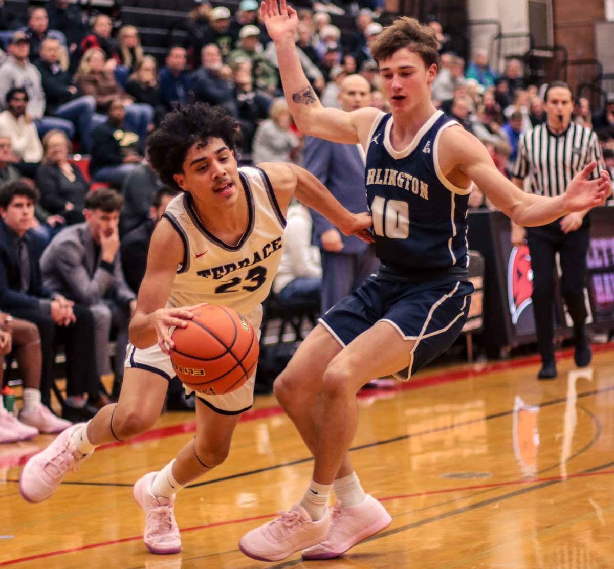 Freshman Anthony Fuentes ran down court ahead of Arlington senior guard Kaid Hunter during the game on Dec. 10 in the Terraceum. 