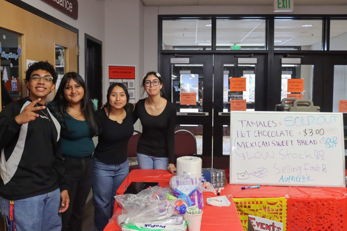 Graduates Jesse Guasch, Katie Larios, senior Neela Lopez-Hernandez, and junior Sabrina Bermudez selling tamales, hot chocolate, and Mexican sweet bread  for the Latino Student Union at the 2023 Holiday Bazaar.