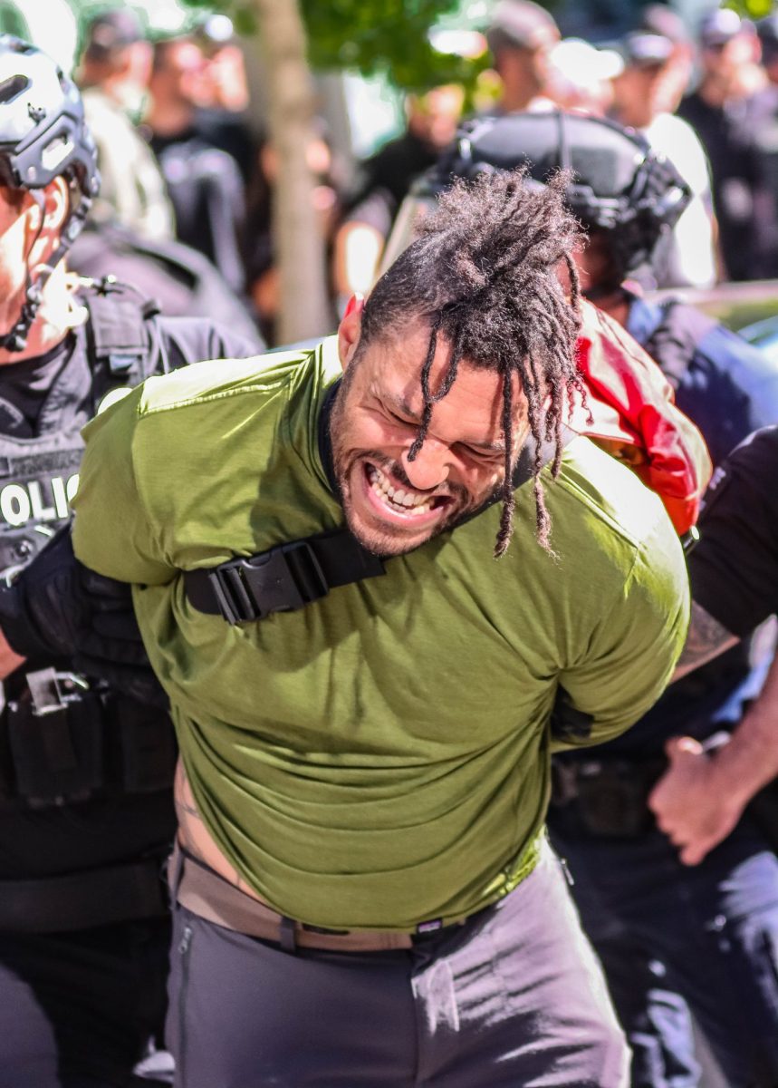 A protester is escorted to a holding vehicle following a bout of violence at the Seattle City Hall protest on May 27. 
