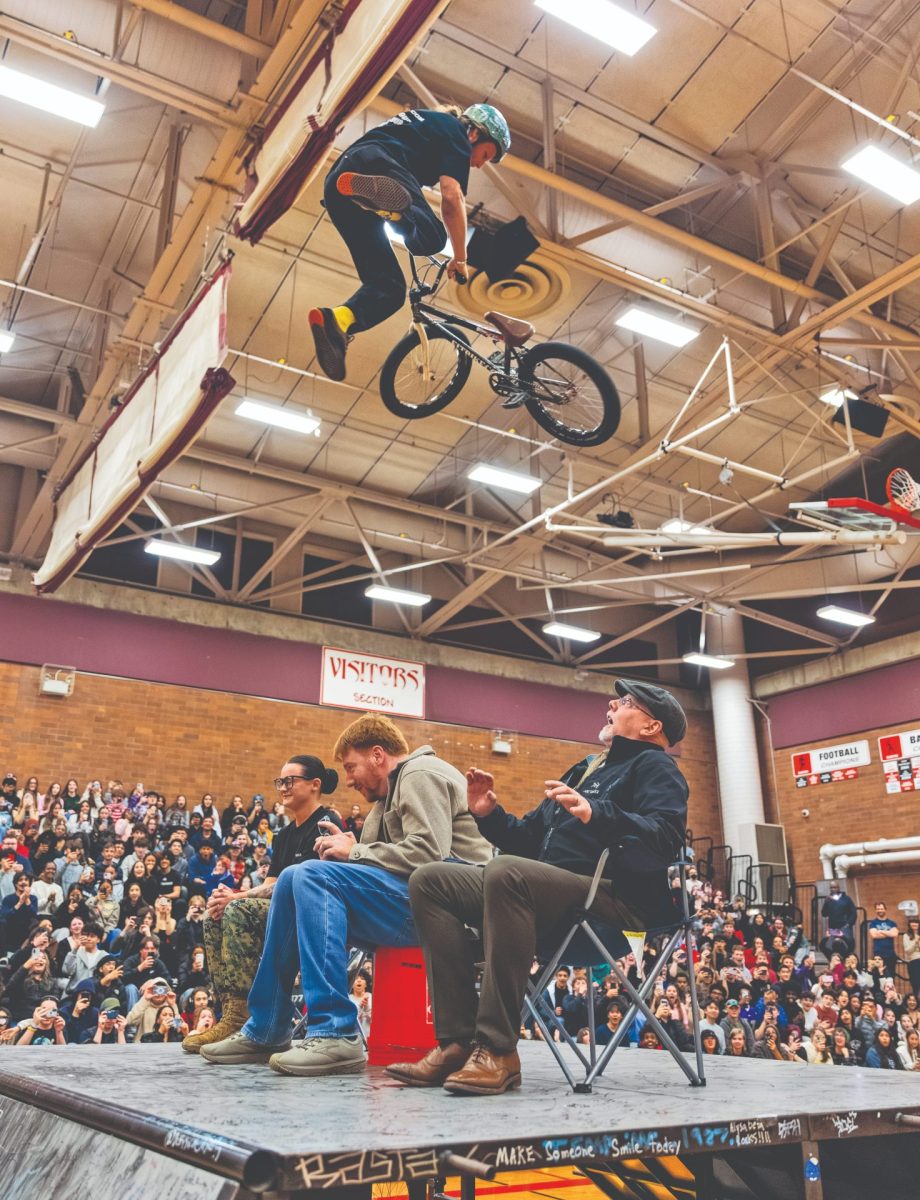 Professional BMX Rider Zach Newman jumping over Principal David Friedle, Jonathan Schaeffer, and a veteran from the Marines at the No Hate Tour in one of two assemblies in the Terraceum April 14.